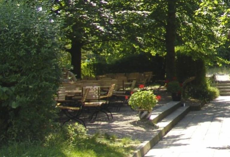 freie Gaststättenplätze unter grünen Bäumen im Sommer